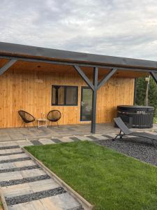 a wooden house with a patio and a grill at KUBIQ 2 Transalpina in Sebeş