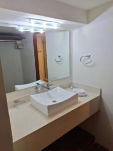 a bathroom with a white sink and a mirror at Depa en planta baja con alberca in Puerto Vallarta