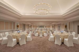 a banquet hall with tables and chairs and a chandelier at The St. Regis Goa Resort in Cavelossim +136 photos