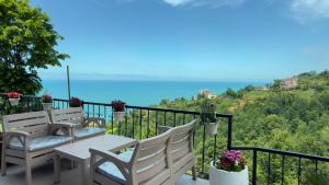 a balcony with a table and chairs and the ocean at cam teraslı köyevi in Cayeli