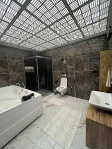 a bathroom with a tub and a sink and a toilet at cam teraslı köyevi in Cayeli