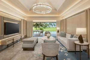 a living room with a couch and a tv at The St. Regis Goa Resort in Cavelossim