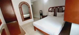 ein Schlafzimmer mit einem weißen Bett und einem Spiegel in der Unterkunft Hotel Santander Veracruz in Veracruz + 4 Fotos