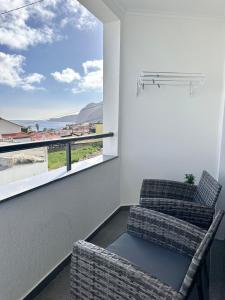 a living room with two chairs and a large window at Waves Madeira I in Caniçal