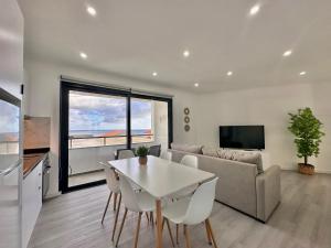 a living room with a table and a couch at Waves Madeira I in Caniçal