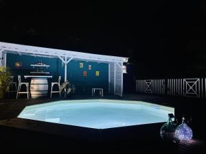 a large swimming pool at night with a bar in the background at Papaye et coconut in Anse-Bertrand