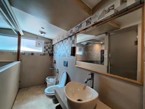 a bathroom with two toilets and a sink and a mirror at The Town Boho in Shimla +23 photos