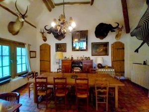 a dining room with a table and some antlers on the wall at Les Gordons in Chaumont-sur-Tharonne