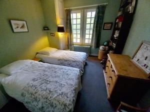 a bedroom with two beds and a window at Les Gordons in Chaumont-sur-Tharonne