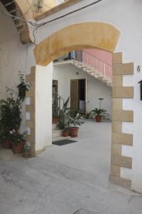 uma entrada para um edifício com vasos de plantas num pátio em Casa Vacanza Nonna Enza em Marsala