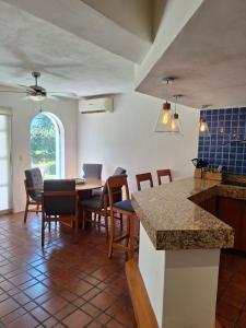 a kitchen and dining room with a table and chairs at Depa en planta baja con alberca in Puerto Vallarta