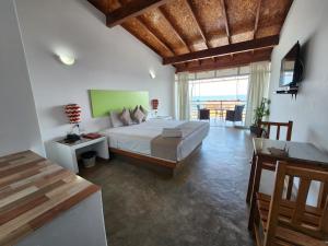 a bedroom with a large bed and a living room at Akas Hotel Apartamentos in Canoas de Punta Sal