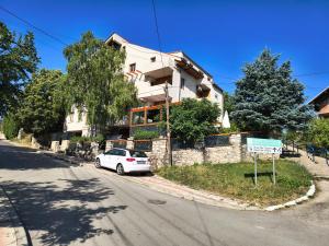 a white car parked in front of a house at APARTMANSKI SMEŠTAJ SOLARIS kod Aqua Parka SUPERIOR & FAMILY Apartments in Soko Banja