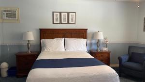 a bedroom with a bed and a blue chair at Bruce Manor in Niagara-on-the-Lake