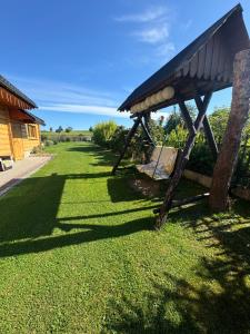 a wooden bench in the grass next to a house at Na Snozie in Milówka
