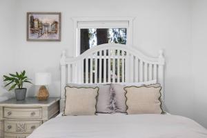 a white bedroom with a white bed with pillows at Seattle cottage in Seattle