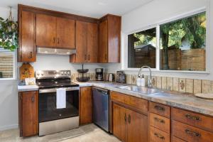 a kitchen with wooden cabinets and a sink and a stove at Seattle cottage in Seattle