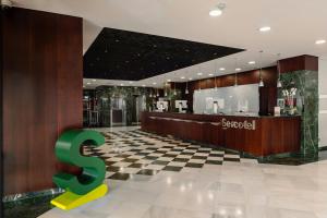 a store lobby with a dollar sign on a checkered floor at Sercotel Amistad Murcia in Murcia