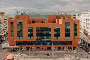 a large orange building in the middle of a city at Sercotel Amistad Murcia in Murcia
