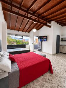 a bedroom with a large red bed and a kitchen at Hotel Ofix - Laureles in Medellín +167 photos