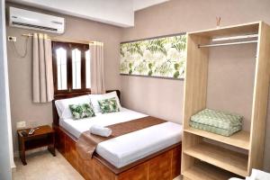 a small bedroom with a bed and a window at HOTEL LUA ORIGENEs in Rodadero