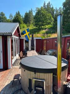 a hot tub on a deck with a house at Tranan' in Karlsborg