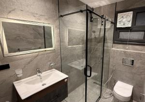 a bathroom with a sink and a glass shower at Panoramic Nile View 3BR Apartment in Cairo +45 photos