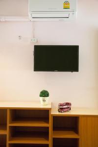 een flatscreen-tv aan een muur bij บ้านภูมิพันธ์ in Hat Yai