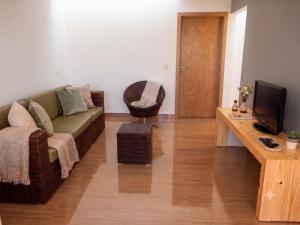 a living room with a couch and a television at Casa com Vista inigualável "Vista del Lago" in Capitólio