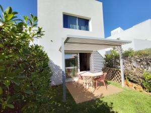 a white house with a table and chairs in the yard at Senhora da Rocha Sea View, Pool, Terrace in Porches