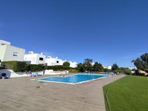 a large swimming pool with people sitting around it at Senhora da Rocha Sea View, Pool, Terrace in Porches
