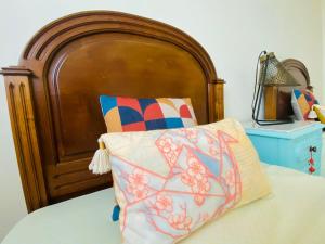 a bed with a wooden headboard and a pillow at Senhora da Rocha Sea View, Pool, Terrace in Porches