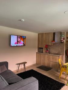 a living room with a couch and a tv on the wall at Risoturismo-Solar de São João - Guest House - in Almeida