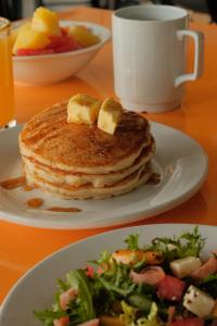 two plates of pancakes and a salad and a cup of coffee at GAMMA Querétaro in Querétaro