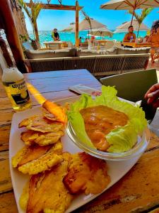 a plate of food with a salad and a bowl of dip at Cabañas W Beach in Cartagena de Indias +67 photos