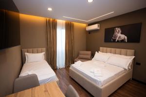 a room with two beds and a chair in it at 2S Vila Boutique Pogradec in Pogradec