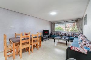 a living room with a table and chairs and a couch at Waterfront apartment in Imiouadar in Agadir nʼ Aït Sa