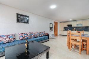 a living room with a blue couch and a table at Waterfront apartment in Imiouadar in Agadir nʼ Aït Sa