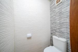a white bathroom with a toilet and a wall at Waterfront apartment in Imiouadar in Agadir nʼ Aït Sa +17 photos