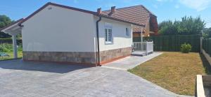 a small white house in a yard with a fence at Casa Lyly in Quincoces de Yuso