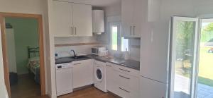 a kitchen with white cabinets and a washing machine at Casa Lyly in Quincoces de Yuso