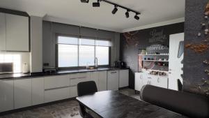 a kitchen with white cabinets and a table and a window at cam teras villa in Cayeli