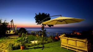 a yellow umbrella and a table and chair with the ocean at cam teras villa in Cayeli