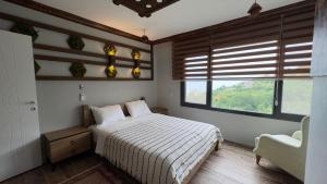 a bedroom with a bed and a chair and a window at cam teras villa in Cayeli +27 photos