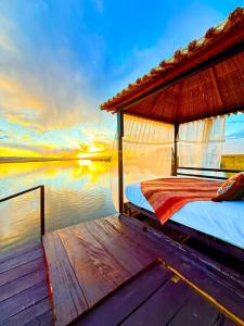 a bed on the back of a boat on the water at KAY PACHA LODGE Uros in Puno