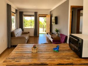 a living room with a wooden table in a room at Casa com Jacuzzi Charme Corumbá in Alexânia