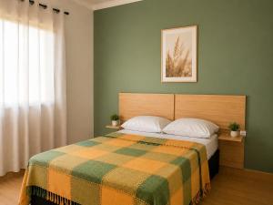 a bedroom with a bed with a colorful blanket at Casa com Jacuzzi Charme Corumbá in Alexânia +14 photos