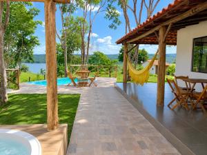an outdoor patio with a hammock and a pool at Casa com Jacuzzi Charme Corumbá in Alexânia