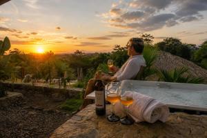 a man sitting in a bath tub with a glass of wine at Stella club & resort in Hacienda La Cabaña