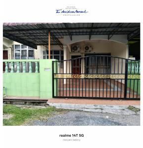 a house with a gate in front of it at Rumah Tamu Maryam in Temerloh